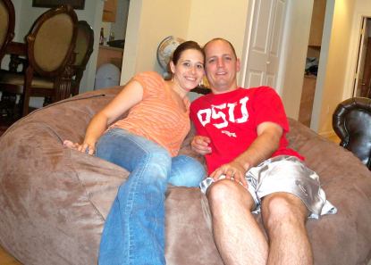 A husband and wife sitting on a giant Fombag
